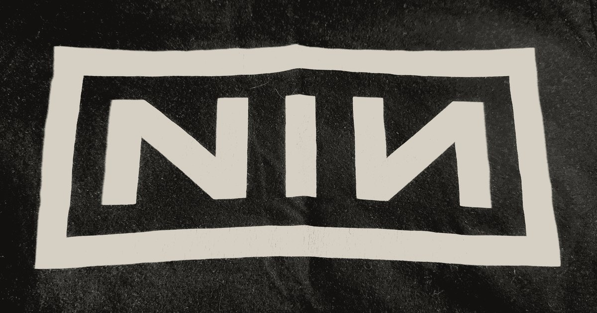 A worn Nine Inch Nails t-shirt, the logo cracked and faded, photocopied